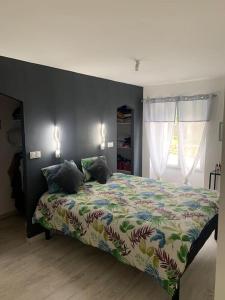 a bedroom with a bed with a colorful comforter at Maison familiale 11 personnes in Lézigné