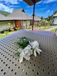 una mesa con flores blancas encima en Rupe Rupe Lodge en Uturoa