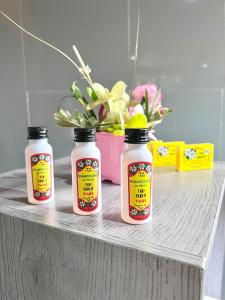 three bottles of sauce sitting on a shelf with a plant at Rupe Rupe Lodge in Uturoa