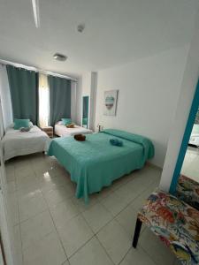 Un dormitorio con 2 camas y una silla. en Ocean house & perfect for you en Adeje