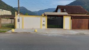 a house with a garage with two balls in front of it at Casa de Praia da Ju - Caraguatatuba in Caraguatatuba