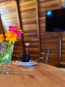 un jarrón con flores sentado en una mesa de madera en Chalés de Lençóis en Lençóis