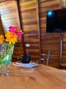 um vaso com flores sentado numa mesa de madeira em Chalés de Lençóis em Lençóis