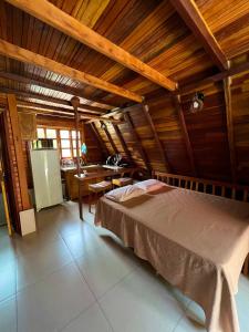 a bedroom with a bed in a room with wooden ceilings at Chalés de Lençóis in Lençóis