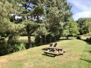 uma mesa de piquenique e duas cadeiras sentadas num campo em Le Petit Lac em Bourganeuf