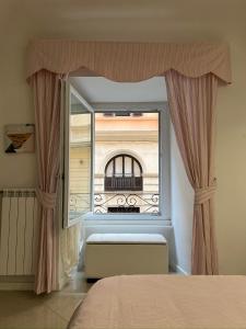 Schlafzimmer mit einem Fenster mit Blick auf ein Gebäude in der Unterkunft Ludovisi Barberini Grand Apartment in Rom