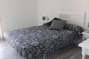 a bedroom with a bed with a black and white blanket at Apartamento acogedor in El Vendrell