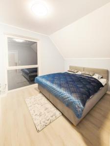 sypialnia z łóżkiem z niebieską kołdrą w obiekcie Domki na wzgórzu w Jamołtówku