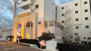un edificio blanco alto junto a un edificio blanco en Appartement Slim centre sousse, en Sousse