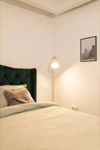 a bedroom with a white bed and a lamp at Ultra central apartment in Baia Mare