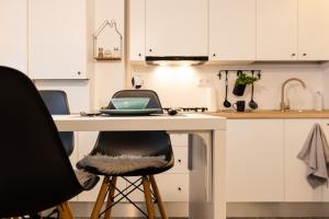 a kitchen with a table with two chairs and a laptop at Ultra central apartment in Baia Mare +7 photos