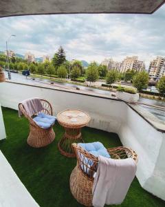 a balcony with three chairs and a table and a table and chairs at Ultra central apartment in Baia Mare
