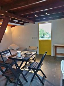 una sala da pranzo con tavolo, sedie e una finestra di Cumbeba Tiny Houses a São Miguel do Gostoso