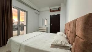a bedroom with a bed with white sheets and a window at Appartement Slim centre sousse in Sousse