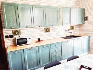 a kitchen with blue cabinets and a microwave at Appartamento vacanze da Paola in Roccabruna