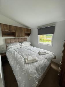 a bedroom with a bed with two towels on it at STORR (caravan skye holidays) in Portree