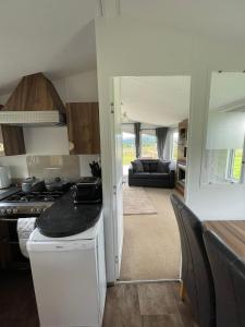 a kitchen and living room with a stove top oven at STORR (caravan skye holidays) in Portree