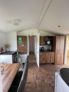 uma cozinha com um sofá e uma mesa num quarto em STORR (caravan skye holidays) em Portree