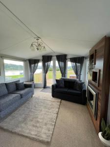 a living room with two couches and a tv at STORR (caravan skye holidays) in Portree