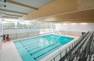 a large swimming pool in a building at Cosy family home w/Wi-Fi, parking, self check-in in London