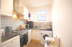 a kitchen with a washing machine and a washer at Cosy family home w/Wi-Fi, parking, self check-in in London