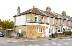 une maison en briques avec une grande fenêtre sur une rue dans l'établissement Cosy family home w/Wi-Fi, parking, self check-in, à Londres