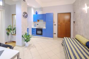 salon z niebieskimi szafkami i kuchnią w obiekcie La Vie en Rose w mieście Cuneo