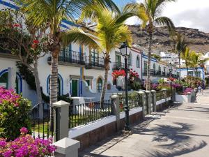 a street in a town with palm trees and houses at Puerto Mogan Casa Feliz in Puerto de Mogán