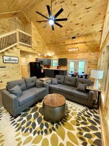 una sala de estar con sofás y una mesa en una cabaña en Hidden 3BR Cabin in the Heart of Red River Gorge!, en Campton