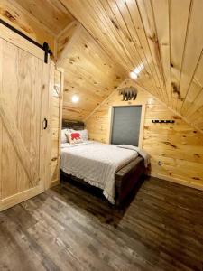 1 dormitorio con 1 cama en una cabaña de madera en Hidden 3BR Cabin in the Heart of Red River Gorge!, en Campton