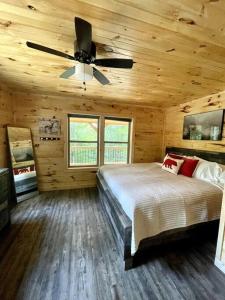 1 dormitorio con 1 cama y ventilador de techo en Hidden 3BR Cabin in the Heart of Red River Gorge!, en Campton