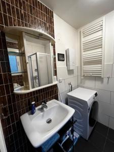 a bathroom with a sink and a toilet and a mirror at Volksgarten Residence in Düsseldorf