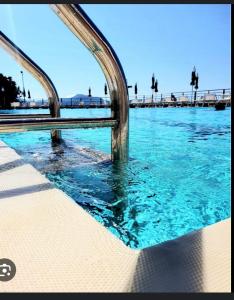 una piscina di acqua blu con un ponte sullo sfondo di Sea & Park a Genova