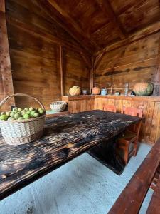 ein Holzzimmer mit einem Tisch und einem Korb mit Äpfeln in der Unterkunft Hanul Apuseni 