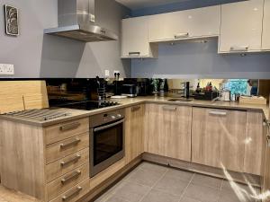 a kitchen with wooden cabinets and a stove top oven at Kings Cross City Apartment in London