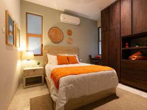 1 dormitorio con 1 cama con manta naranja en Carmensita en San José del Cabo