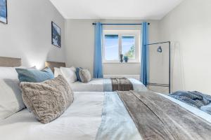 een slaapkamer met 2 bedden en een raam bij MK 2-Bedroom Contractor's Gem, 5 beds, sleeps 6, free parking in Milton Keynes
