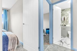 - une chambre avec une porte menant à une salle de bains dans l'établissement MK 2-Bedroom Contractor's Gem, 5 beds, sleeps 6, free parking, à Milton Keynes