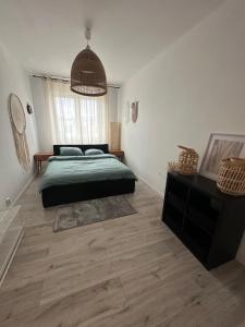 sypialnia z zielonym łóżkiem i dużym oknem w obiekcie Airport Apartment Regata Kiekrz lotnisko w mieście Baranowo