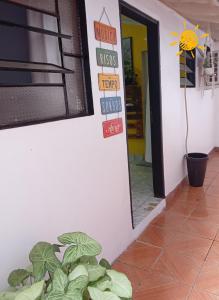 a room with signs on the wall and a plant at El Viajero Hostel & Suítes 11 in Pedro Juan Caballero