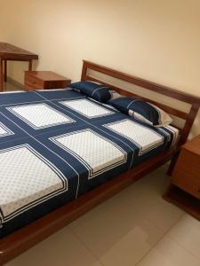 a bed with blue and white sheets and pillows at Constança Retreat in Mindelo