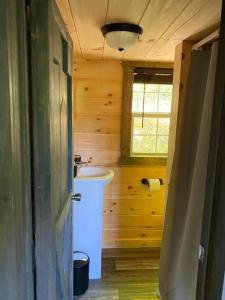 Elle comprend une petite salle de bains pourvue d'un lavabo et d'une fenêtre. dans l'établissement Red River Gorge Couples and Climbing getaway in Prime Location!, à Campton