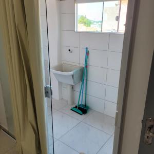 baño con fregona y lavamanos en Apartameto 2 quartos perto da praia e Beto Carrero, en Penha