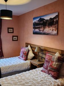 1 dormitorio con 2 camas y un cuadro en la pared en Appartement ' Le Lupulus', en Bilwisheim