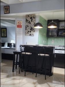 a kitchen with black bar stools and a bedroom at Mystic Ridge Paradise in Ocho Rios