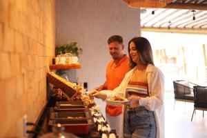 a man and a woman holding a plate of food at Uri Pousada in Maragogi