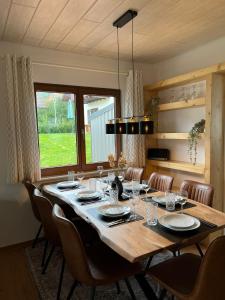 uma sala de jantar com uma grande mesa de madeira e cadeiras em Ferienhaus Seepark Kirchheim em Kirchheim