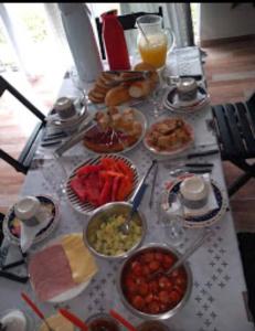 una mesa con muchos platos de comida. en Pousada Luzemar flat, en São Francisco do Sul