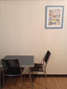 uma mesa e cadeiras num quarto com uma fotografia na parede em Chambres d'hôtes du Péras em Saint-Jean-du-Gard