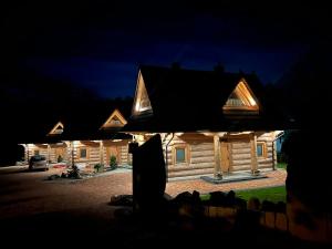 ein Blockhaus in der Nacht mit Lichtern in der Unterkunft LITTLE KOIS VILLAGE in Dzianisz